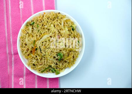 Indian vegetarian pulao or Veg fried rice or Veg Briyani in brown decorated wooden bowl with isolated white background. Indian rice dish. Stock Photo