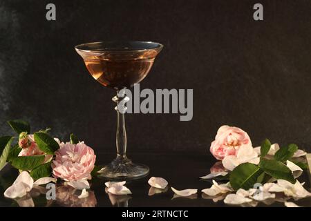 Glass of pink champagne with rose flowers on the black background Stock Photo