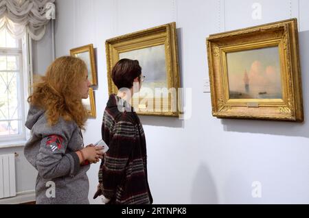Young women visitors looking at paintings at the exhibition hall. National Museum Kyiv Art Gallery. September 28, 2021. Kyiv, Ukraine. Stock Photo