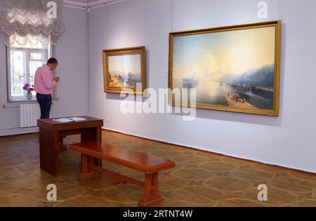 Man visitor looking at paintings at the exhibition hall. National Museum Kyiv Art Gallery. September 28, 2021. Kyiv, Ukraine. Stock Photo