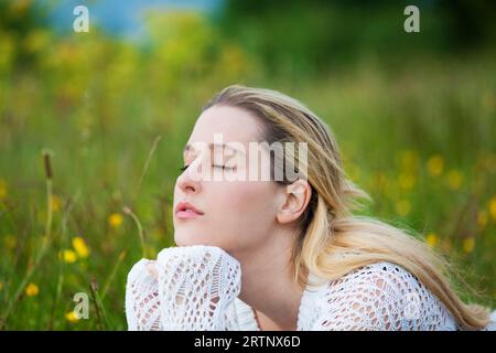 young lady breathing fresh air in field Stock Photo