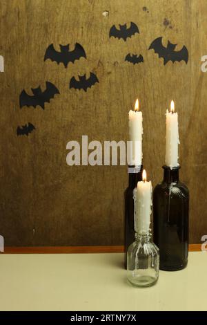 halloween still life with black paper bats and burning candles Stock Photo