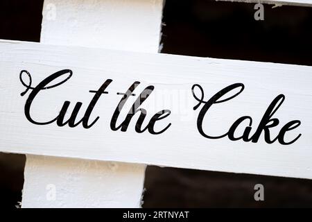 Cut the wedding cake sign black text on wooden white background Stock Photo