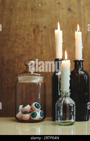 halloween still life with a jar of eyeballs and glowing candles Stock Photo