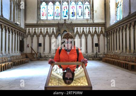 Tourist visitor looking into a mirror to view the ceiling of the Chapter House, Canterbury Cathedral, Kent Stock Photo