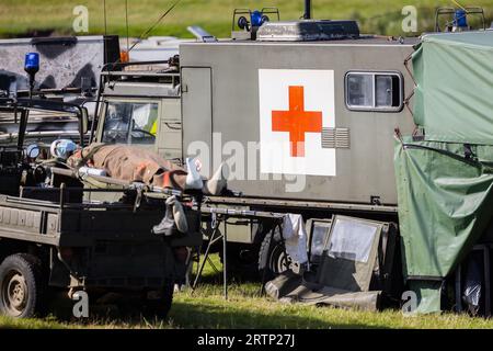 Military soviet era first aid base red cross with army vehicles combat medics and stretcher Stock Photo