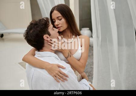 couple harmony, tattooed woman touching face of boyfriend during their romantic getaway, vacation Stock Photo