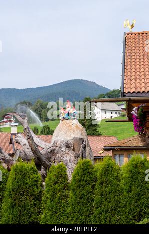 garden gnomes on top of a rock with mountains in the background Stock Photo