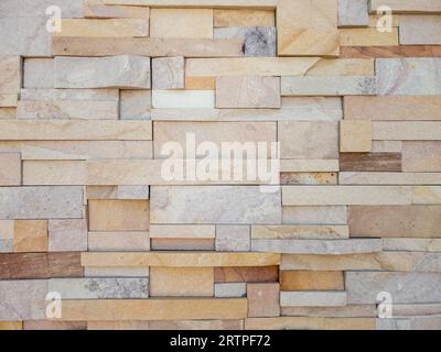 The cladding stone wall is decorated on the building pole of the countryside house, front view for the background. Stock Photo