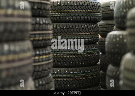 Sale of car tires for sale in the store. Many new winter tires lie Stock Photo