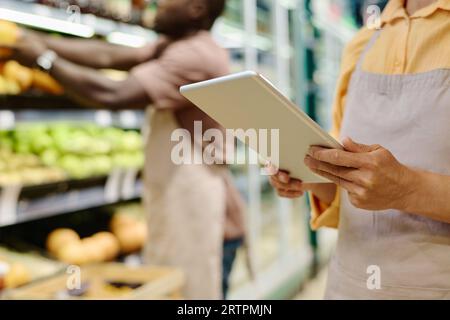 Close-up of manager of supermarket using tablet pc at her work Stock Photo