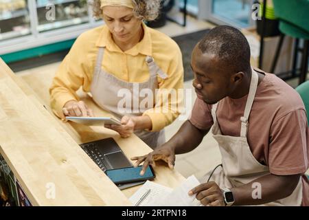High angle view of worker using computer together with manager to make an audit in supermarket Stock Photo