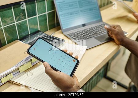 Close-up of supermarket worker using calculate to make finance work at his workplace Stock Photo