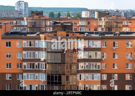 High-rise works. Rock-climbers  cleaning window. Industrial mountaineering.group of workers cleaning window on high rise building Stock Photo
