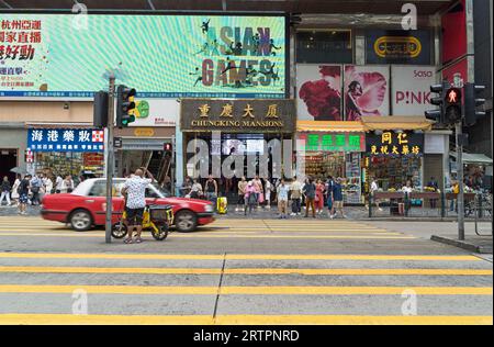 Chungking Mansions on Nathan Road in Tsim Sha Tsui. A building with many low budget hotels, shops and restaurants on a busy shopping street. Hong Kong Stock Photo