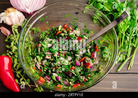 Freshly Made Chimichurri in a Glass Mixing Bowl: A South American condiment made with parsley, olive oil, and vinegar Stock Photo