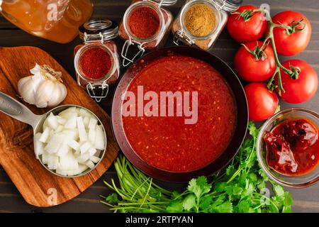 Homemade Sofrito Surrounded by Spices and Vegetables: A bowl of sofritas sauce surrounded by fresh ingredients and dried spices Stock Photo