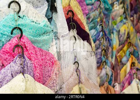Multi-colored scarves on the counter of a trade tent at a fair. Selective sharpening, background. Small business. Stock Photo