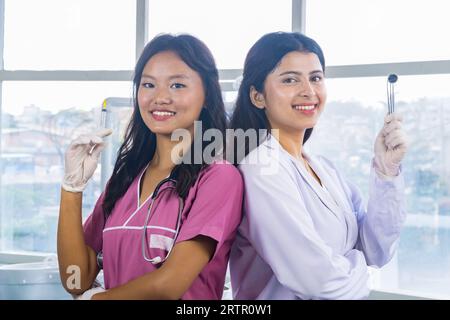 Two Confident Asian Nurse and Doctor standing side by side in a hospital Stock Photo
