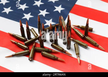 Bullets for firearms, combat army cartridges on the American flag. The concept of lend-lease, the supply of weapons, support, arms sales. Stock Photo