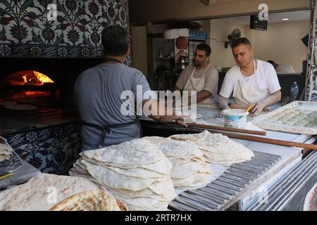 Bakers preparing dough to make traditional Turkish flat bread to be baked in an oven kiln, in Istanbul, Turkey Stock Photo