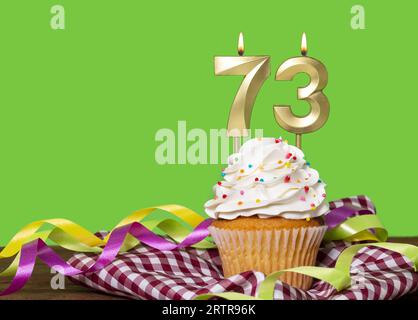 Birthday Cake With Candle Number 73 - On Green Background. Stock Photo