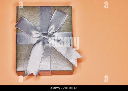 Silver Gift Box with Ribbon and Bow isolated on Orange Stock Photo