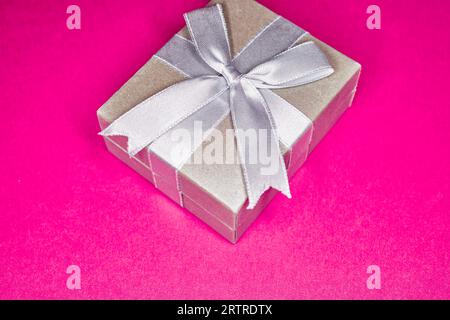 Silver Gift Box with Ribbon and Bow isolated on Pink Stock Photo