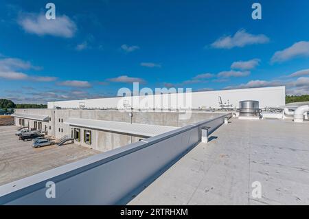 View of the roof of a new cold-storage facility, showing stainless-steel housings and insulated piping. Stock Photo