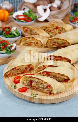 Swabian cuisine, hearty potato strudel, salty strudel with vegetable filling, baked, oven dishes, main course, healthy, strudel sliced on wooden Stock Photo