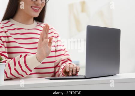Woman having video chat via laptop at white table indoors, closeup Stock Photo