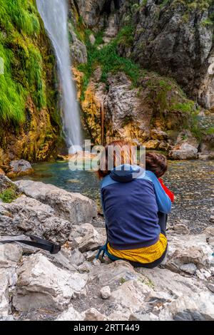 Woman with her child at Grunas waterfall in Theth national park, Albania. Albanian alps Stock Photo