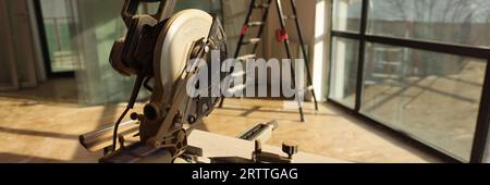 Electric circular saw on stand and wooden board close up. Stock Photo