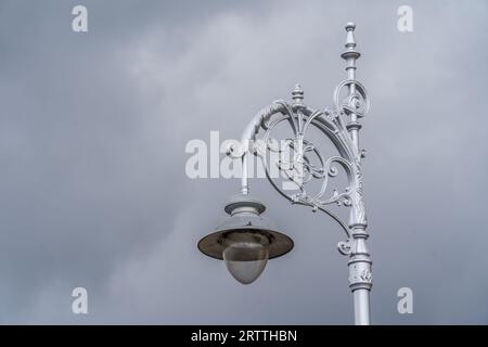 Close up shot of ornamented silver lamp post street light in Dublin Ireland with grey sky background Stock Photo