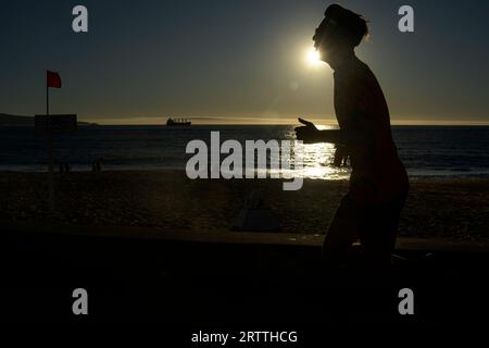 September 14, 2023, Vina del Mar, Valparaiso, Chile: Daily life at Las Salinas beach, ViÃ±a del Mar, Chile. A man running along the sidewalk of the waterfront during a hot winter afternoon on September 14, 2023. (Credit Image: © Eduardo Hidalgo/ZUMA Press Wire) EDITORIAL USAGE ONLY! Not for Commercial USAGE! Stock Photo