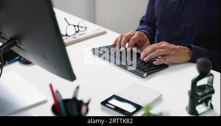 Man Working In Office On Desktop PC Stock Photo