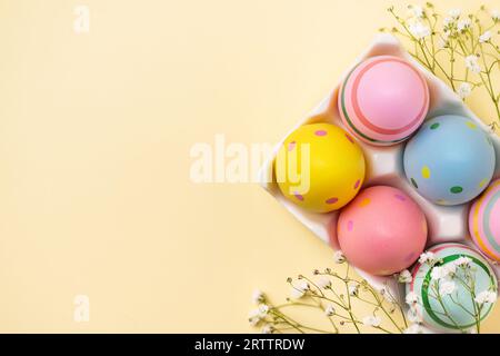 Colourful Easter eggs and gypsophila flowers background. Easter holiday composition with easter eggs with copy space. Stock Photo