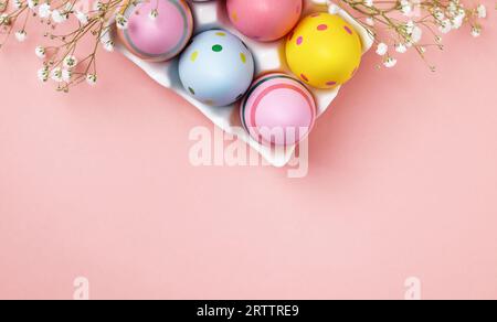 Colourful Easter eggs and gypsophila flowers background. Easter holiday composition with easter eggs with copy space. Stock Photo