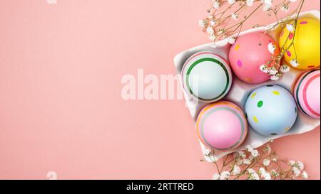 Colourful Easter eggs and gypsophila flowers background. Easter holiday composition with easter eggs with copy space. Stock Photo