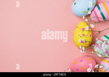 Colourful Easter eggs and gypsophila flowers background. Easter holiday composition with easter eggs with copy space. Stock Photo