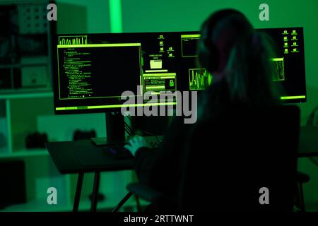 Cyber security hacker code malware to exploit vulnerability in program or system on a computer in a dark room Stock Photo