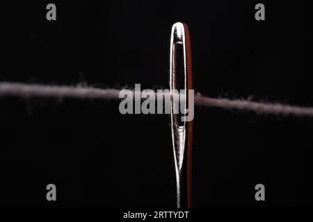 closeup photo of sewing thread in needle hole Stock Photo