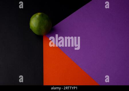 photo of green lemon on colored papers Stock Photo