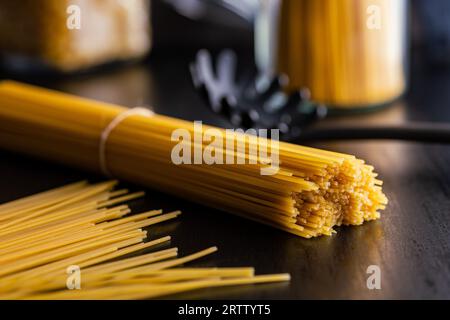Spaghetti pasta. Uncooked italian pasta on a  black table. Stock Photo