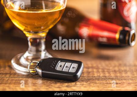 Car key with beer glass on a wooden table. Booze driving concept. Drunk driver concept. Stock Photo