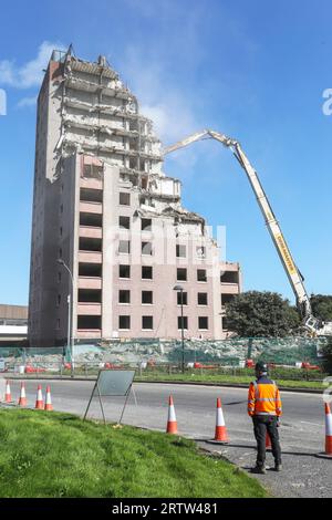 High rise block of flats, Irvine, Ayrshire, Scotland, UK, being demolished by a mechanical crane. Stock Photo