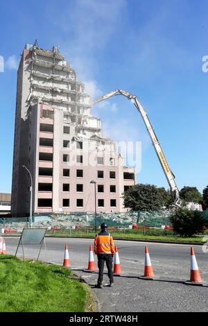 High rise block of flats, Irvine, Ayrshire, Scotland, UK, being demolished by a mechanical crane. Stock Photo