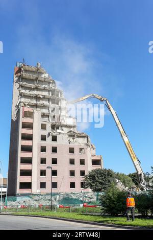 High rise block of flats, Irvine, Ayrshire, Scotland, UK, being demolished by a mechanical crane. Stock Photo