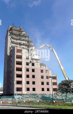 High rise block of flats, Irvine, Ayrshire, Scotland, UK, being demolished by a mechanical crane. Stock Photo