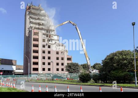 High rise block of flats, Irvine, Ayrshire, Scotland, UK, being demolished by a mechanical crane. Stock Photo